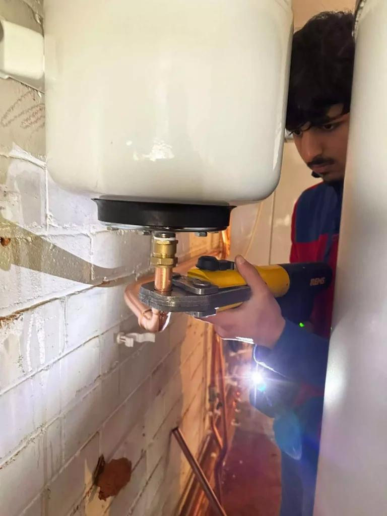 Plumber fixing a leaking pipe in a Bradford home